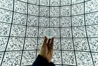 person holding clear glass ball with QR code background